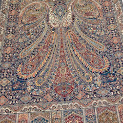 Decorative shawl with intricate patterns on a light wooden floor.