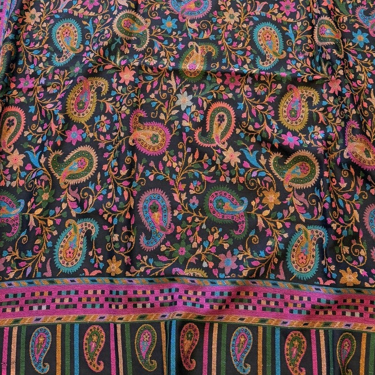 Colorful paisley patterned fabric on a yellow surface