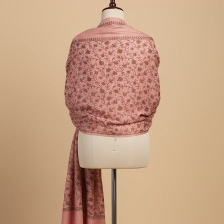 Mannequin wearing a pink patterned shawl on a beige background
