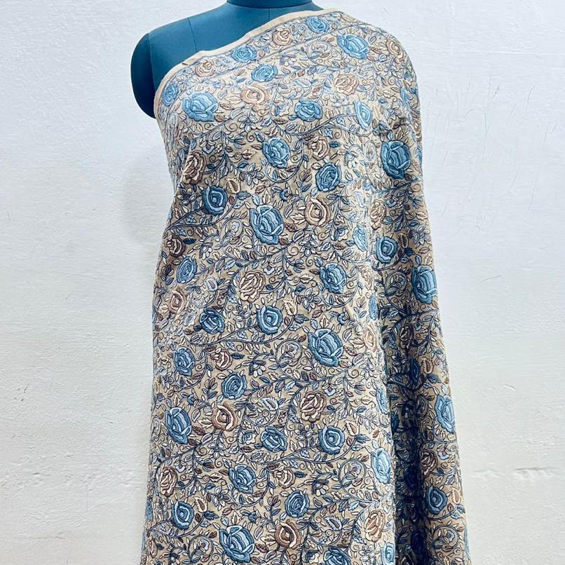 Beautiful Sozni embroidery shawl in beige with blue embroidery draped over a female model