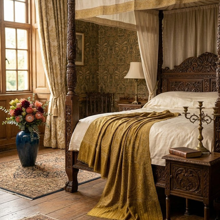 Decorative bedroom with a large wooden four-poster bed, floral arrangement, and lamp.