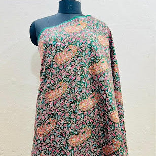 A multicolor printed fabric draped on a black dress form mannequin, featuring a green base with pink paisley and floral motifs.