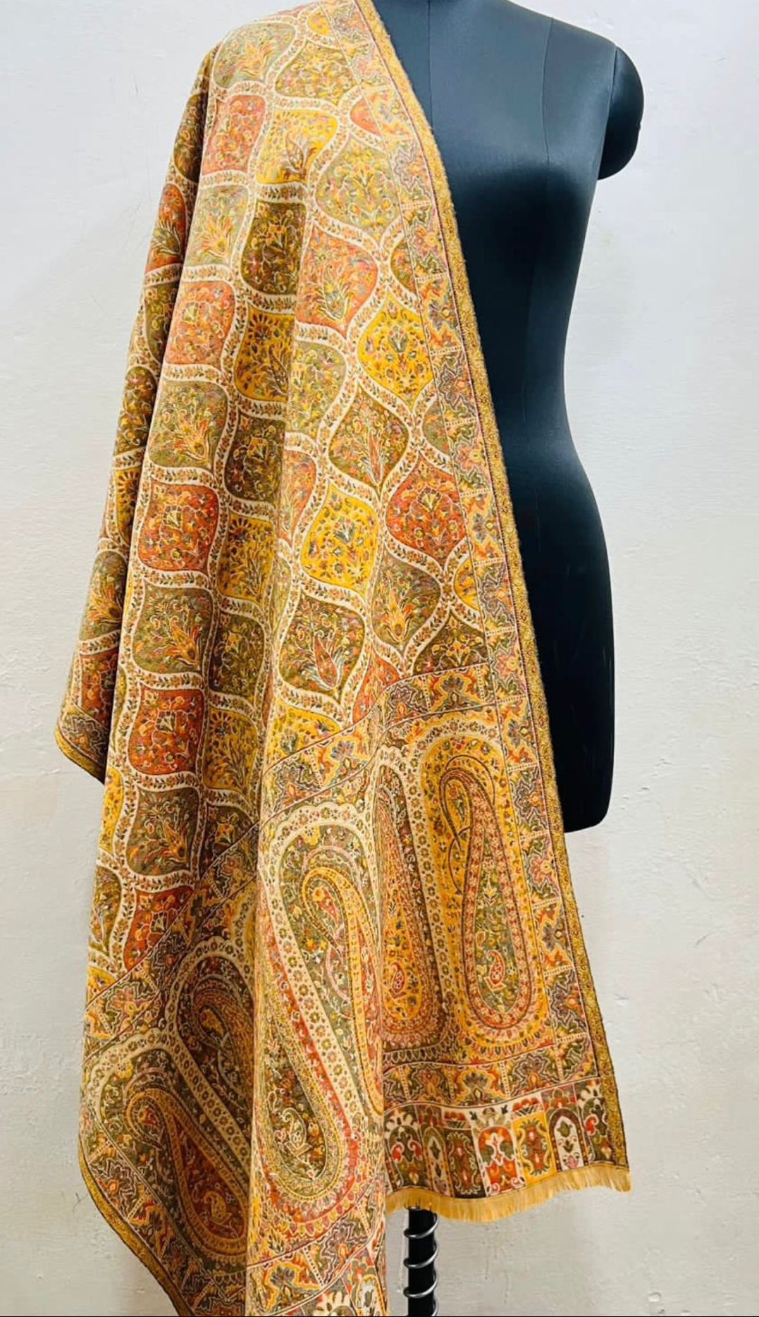 Yellow patterned kalamakari kani double beam stole in pure wool draped over a mannequin against a white background