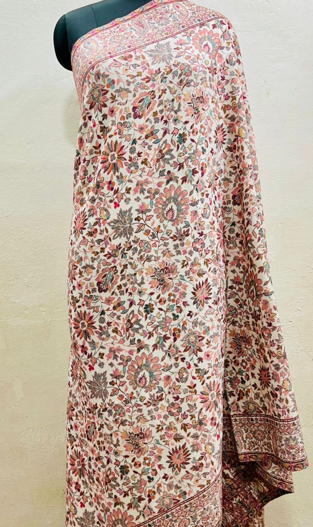 Floral patterned floral pure wool shawl in kani design draped over a mannequin on a plain background