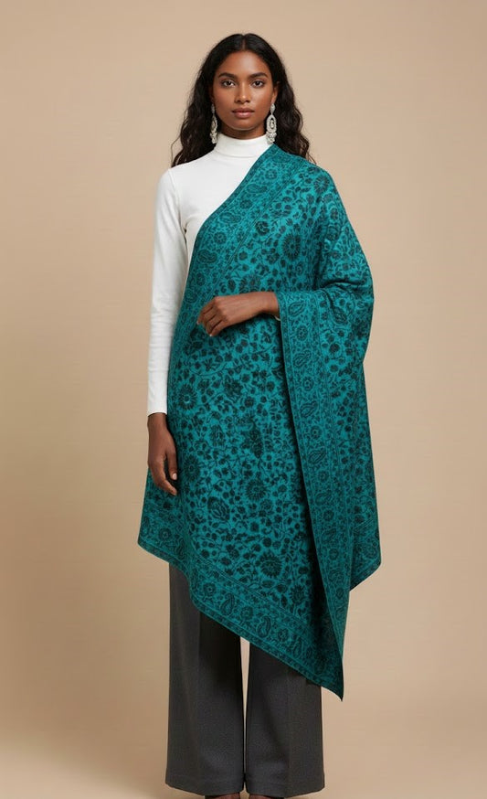 Model wearing a blue patterned faux Pashmina stole on a beige background