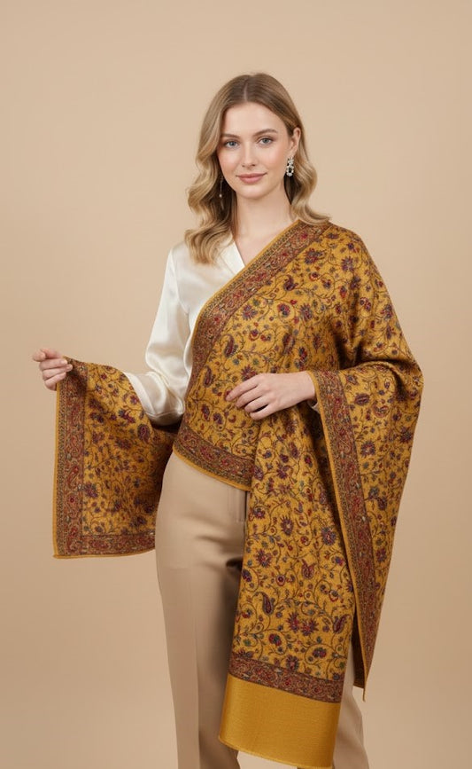 Woman wearing a mustard yellow patterned shawl on a beige background