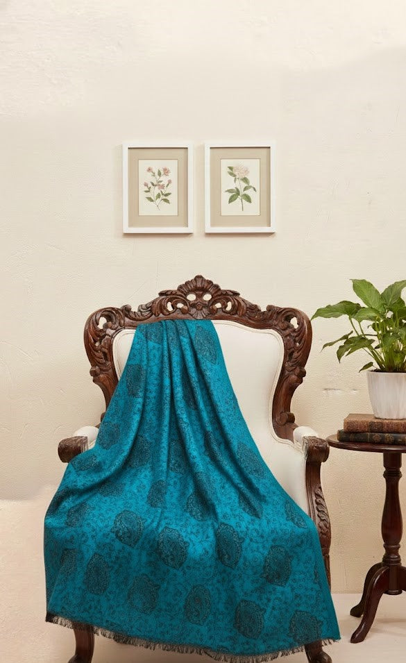 Blue faux Pashmina stole draped over a wooden chair with a neutral background