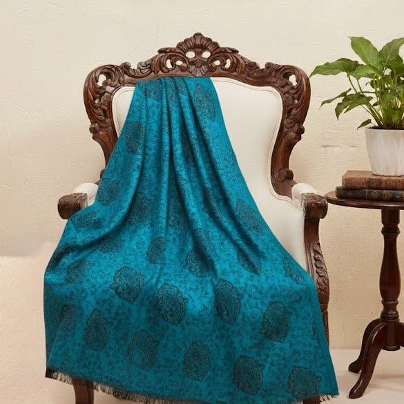 Blue faux Pashmina stole draped over a wooden chair with a neutral background