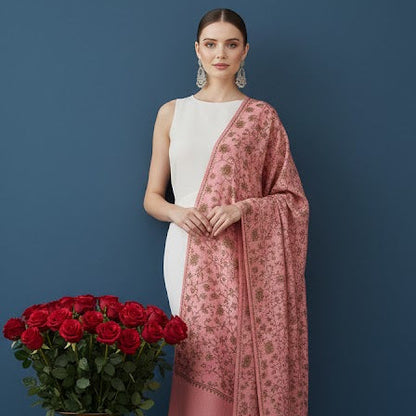 Woman holding a pink scarf next to a vase of red roses against a blue background