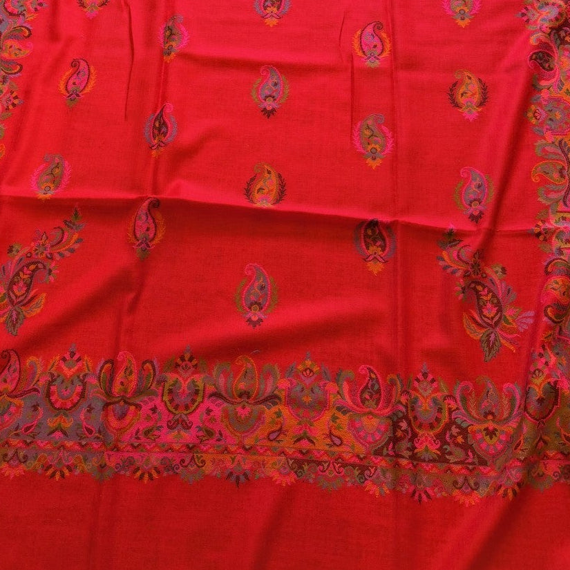 Red fabric with gold patterns on a wooden floor