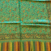 Green fabric with floral patterns on a wooden floor