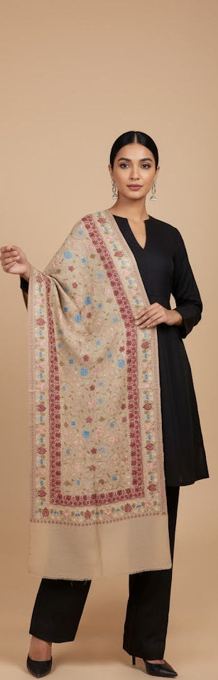 Woman holding a patterned shawl against a beige background