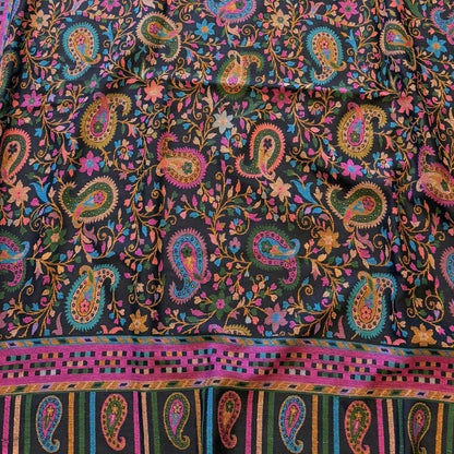 Colorful paisley patterned fabric on a yellow surface