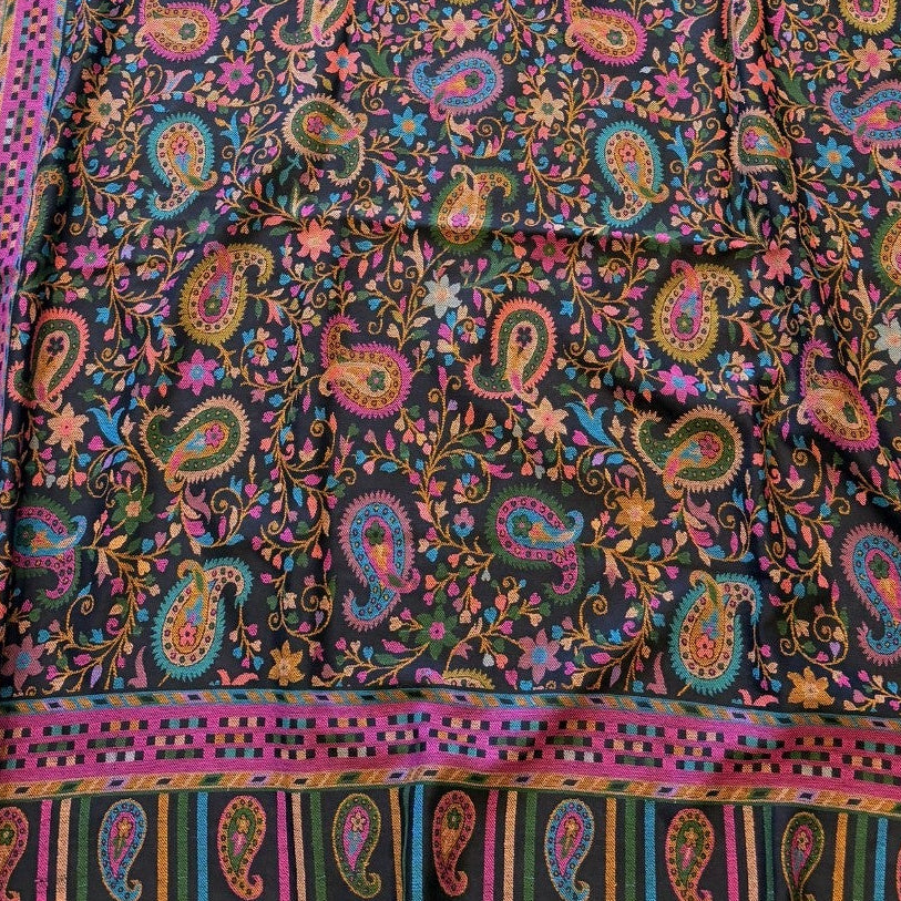 Colorful paisley patterned fabric on a yellow surface