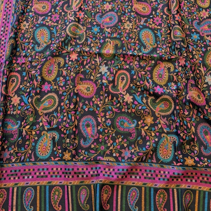 Colorful paisley patterned fabric on a yellow surface