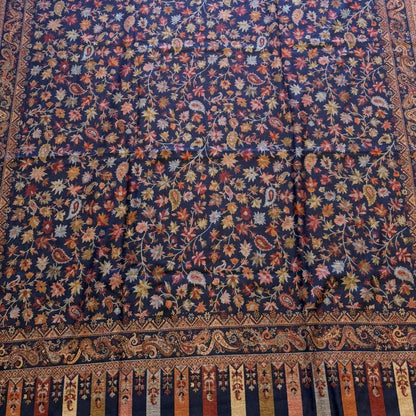 Decorative shawl with intricate patterns on a light wooden floor.