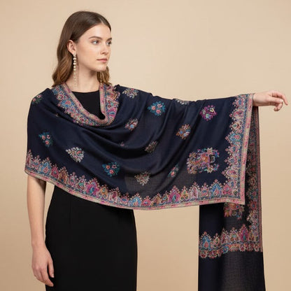Woman wearing a navy blue scarf with intricate patterns on a beige background