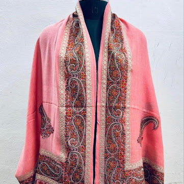 Pink shawl with intricate patterns on a mannequin against a white background