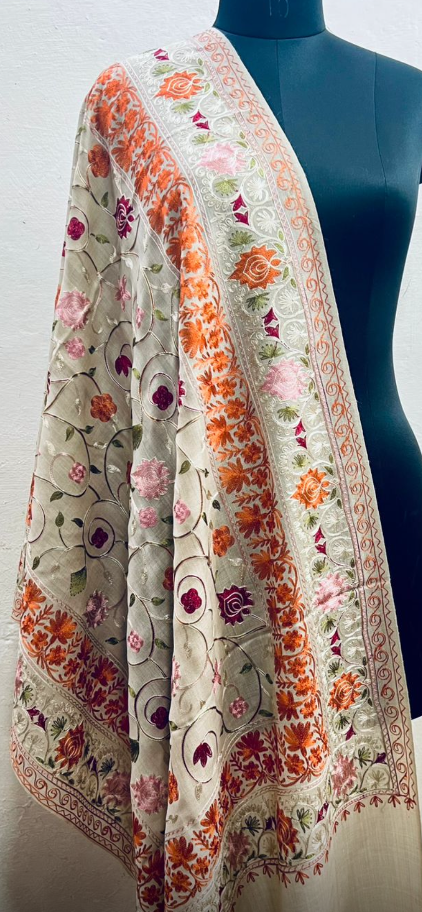 Floral patterned shawl draped over a mannequin against a white background