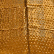 Gold patterned fabric on a wooden floor