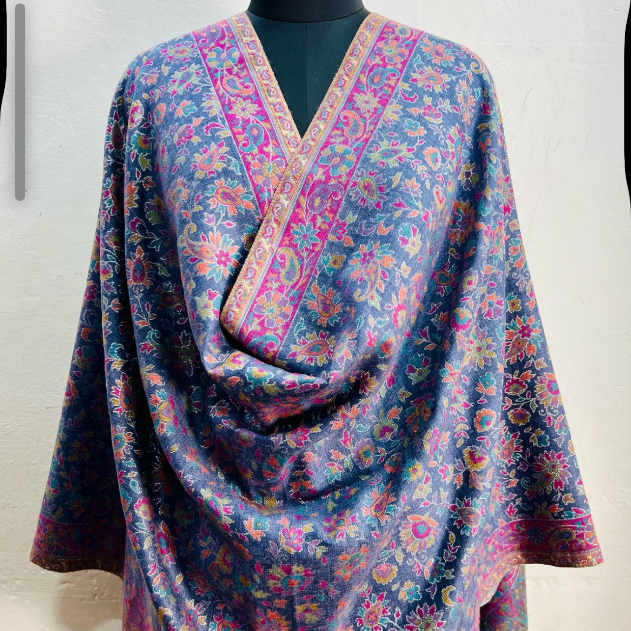 Floral patterned shawl on a mannequin against a white background