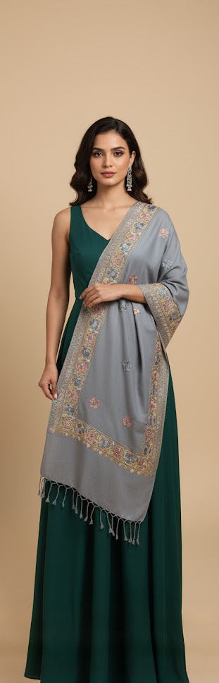 Woman wearing a green dress with a patterned shawl on a beige background