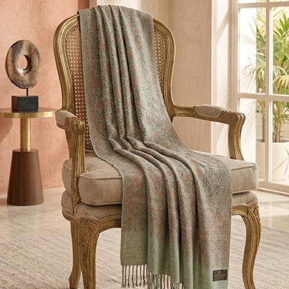 Woven chair with a green and beige plaid blanket draped over it in a room with large windows.