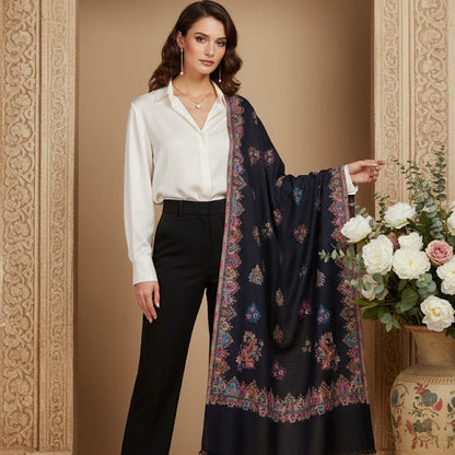 Woman holding a floral-patterned scarf in a decorative setting with a vase of flowers.