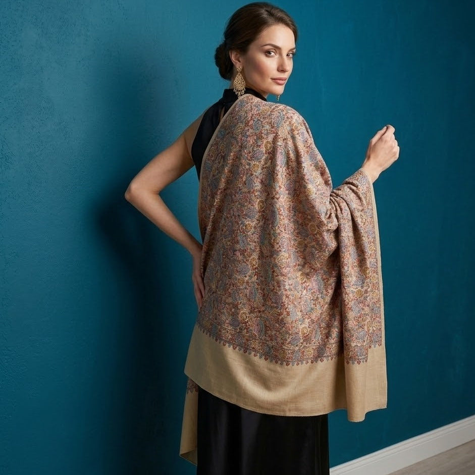 Woman wearing a patterned shawl against a blue wall