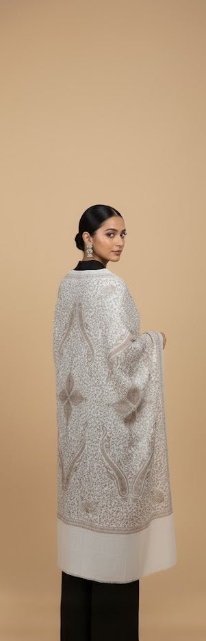 Woman wearing a patterned shawl on a beige background