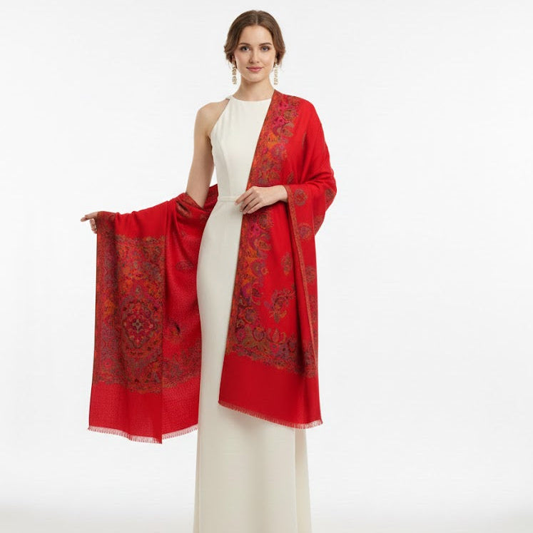 Woman wearing a red patterned shawl over a white dress on a white background