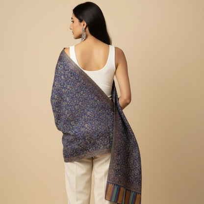 Woman wearing a patterned shawl over her shoulders against a beige background