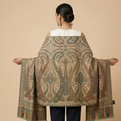 Woman wearing a large patterned shawl on a beige background
