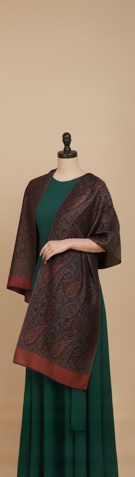 Mannequin wearing a green dress with a maroon  patterned shawl against a beige background