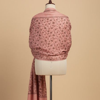 Mannequin wearing a pink patterned shawl on a beige background