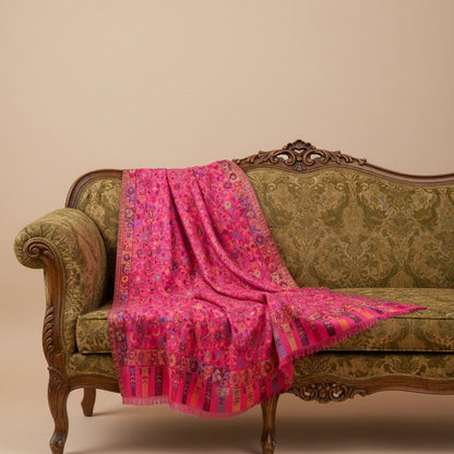 Pink patterned scarf draped over a decorative green sofa against a beige background