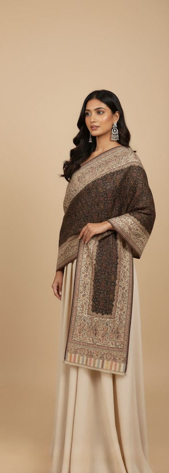 Woman wearing a traditional outfit with a brown and beige shawl on a beige background