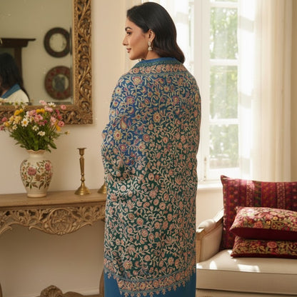 Woman wearing a floral embroidered kurta in a decorated room.