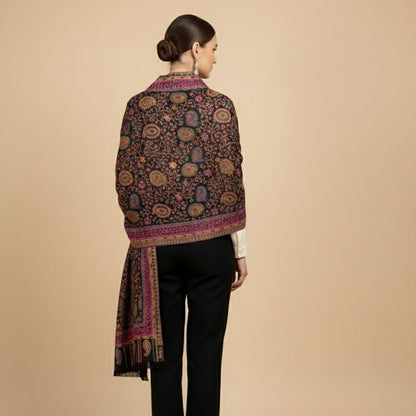 Woman wearing a patterned shawl over a plain garment on a beige background