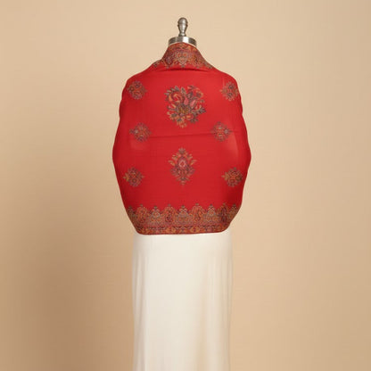 Red embroidered garment on a mannequin against a beige background