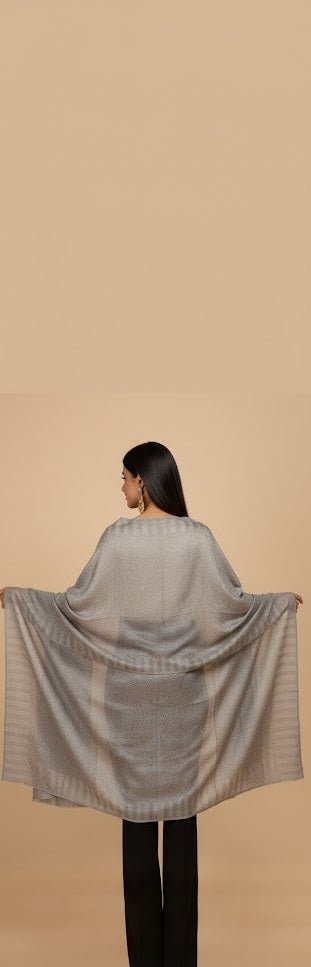 Woman wearing a light gray checkered shawl on a beige background