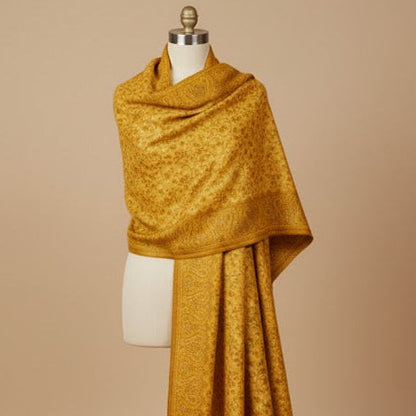 Mustard yellow shawl draped over a mannequin against a beige background