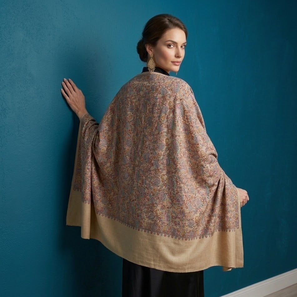 Woman wearing a patterned shawl against a blue wall
