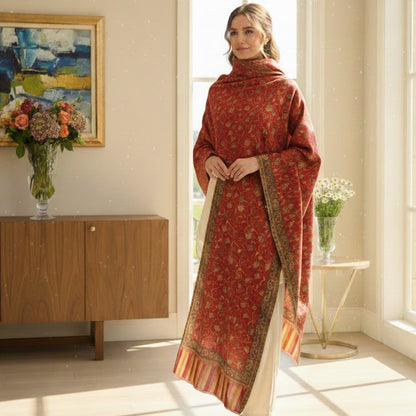 Woman in a red patterned outfit standing in a bright room with large windows.