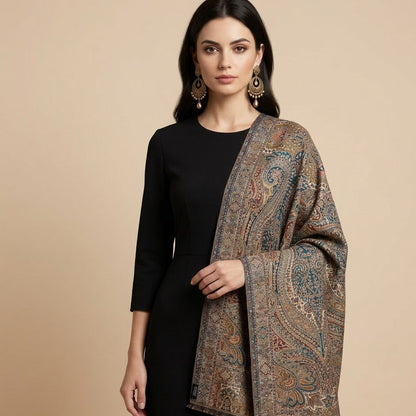 Woman wearing a patterned shawl over a black outfit on a beige background