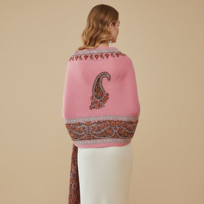 Woman wearing a pink shawl with intricate patterns on a beige background