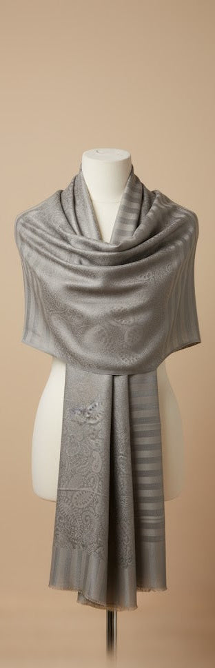 Gray shawl on a mannequin against a beige background
