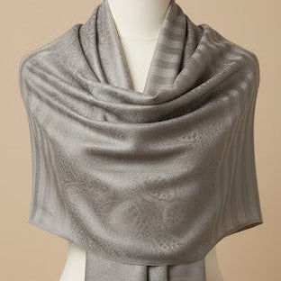 Gray shawl on a mannequin against a beige background