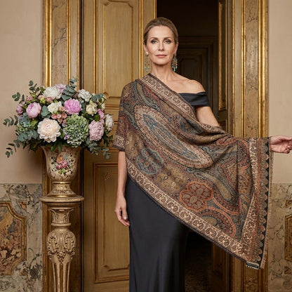 Woman wearing a patterned shawl in an elegant interior setting with flowers and decorative elements.