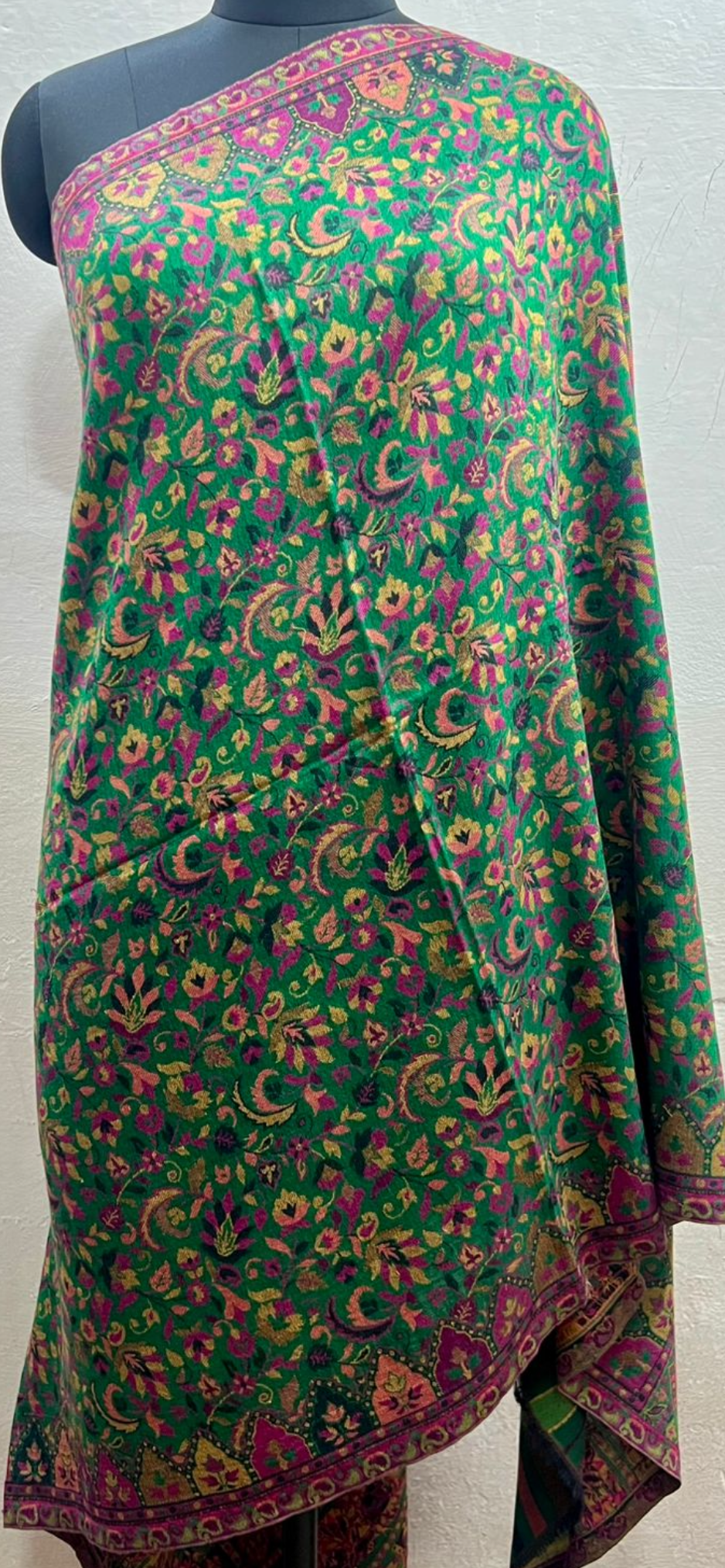 Green floral patterned shawl draped over a mannequin
